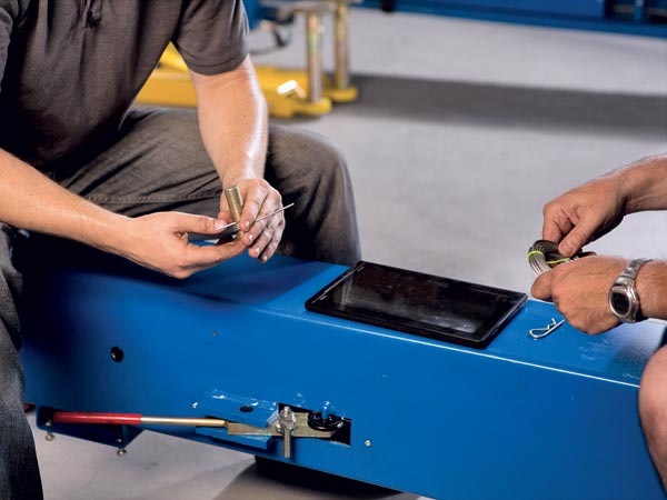 Technician servicing a vehicle hoist